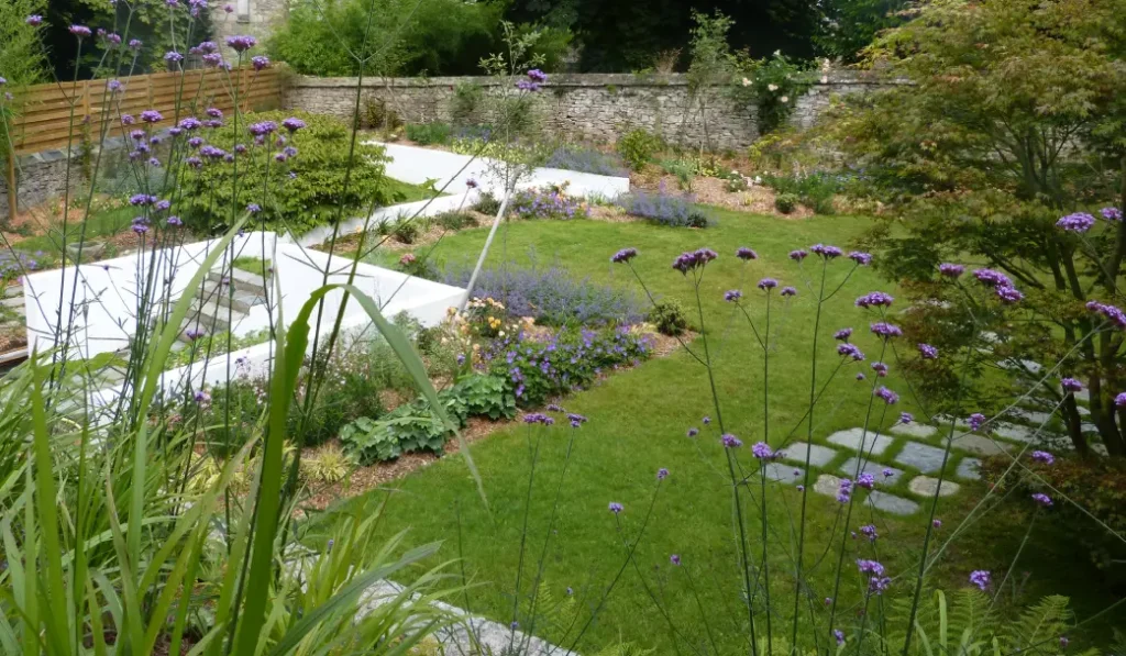 Jardin paysager aménagé avec des massifs fleuris, des allées en pierre et une pelouse bien entretenue à Lannion, Trégor, Côtes-d’Armor.