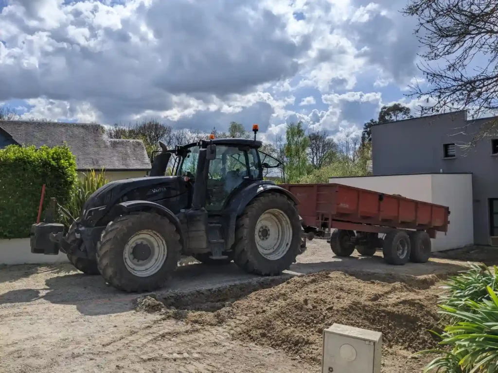 Travaux d’aménagement paysager réalisés par les Établissements Rochelle dans le Trégor avec un tracteur et remorque en intervention sur un chantier résidentiel